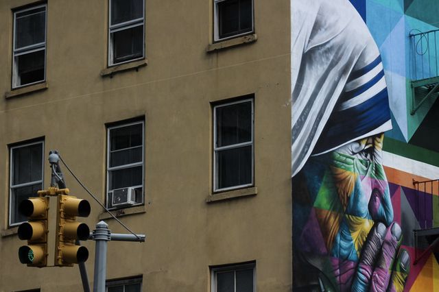 A large colorful mural of Mother Teresa on the side of a NYC building.